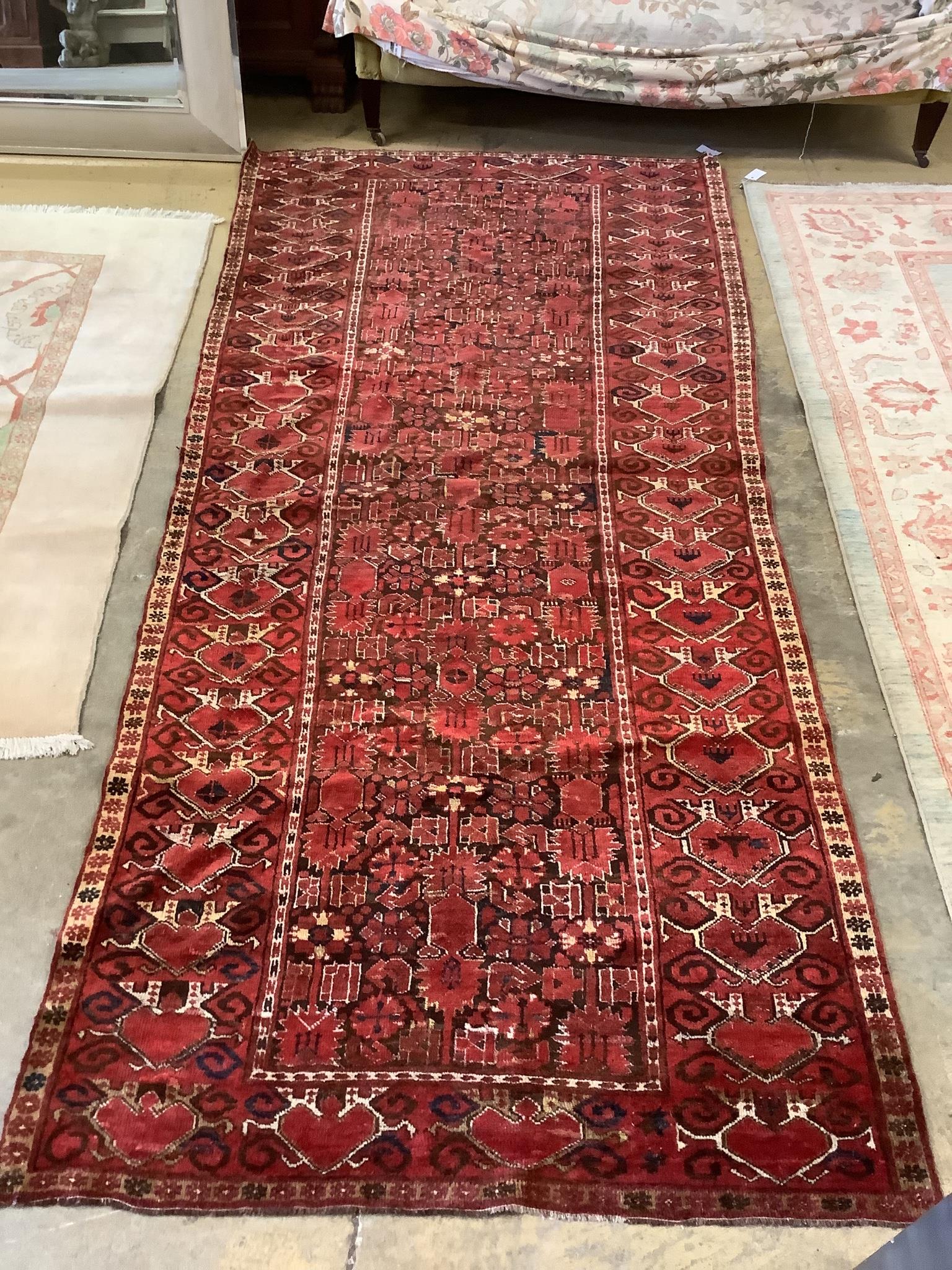 An Afghan red ground rug, 290 x 140cm